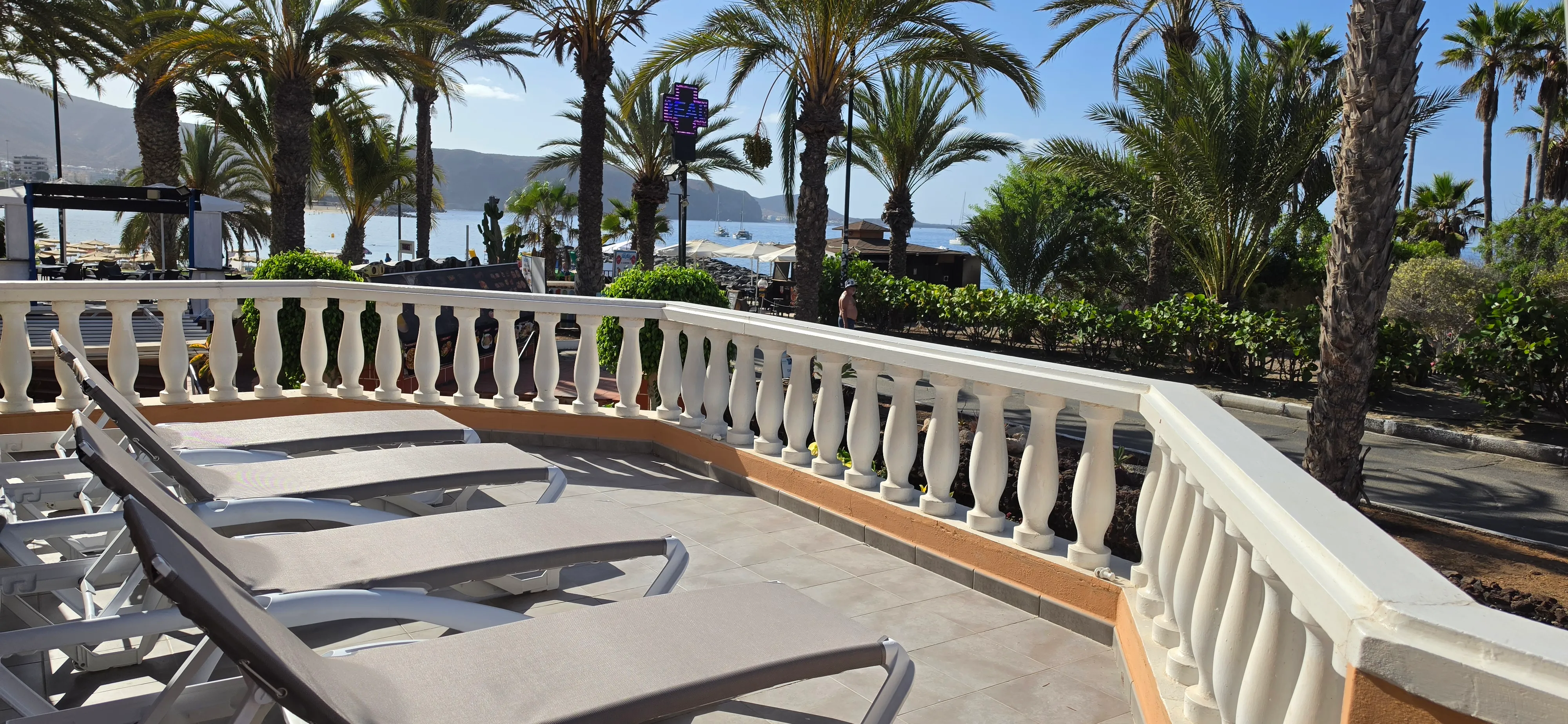 Sonnenterrasse mit Liegen und Blick über Playa de las Vistas zum Meer