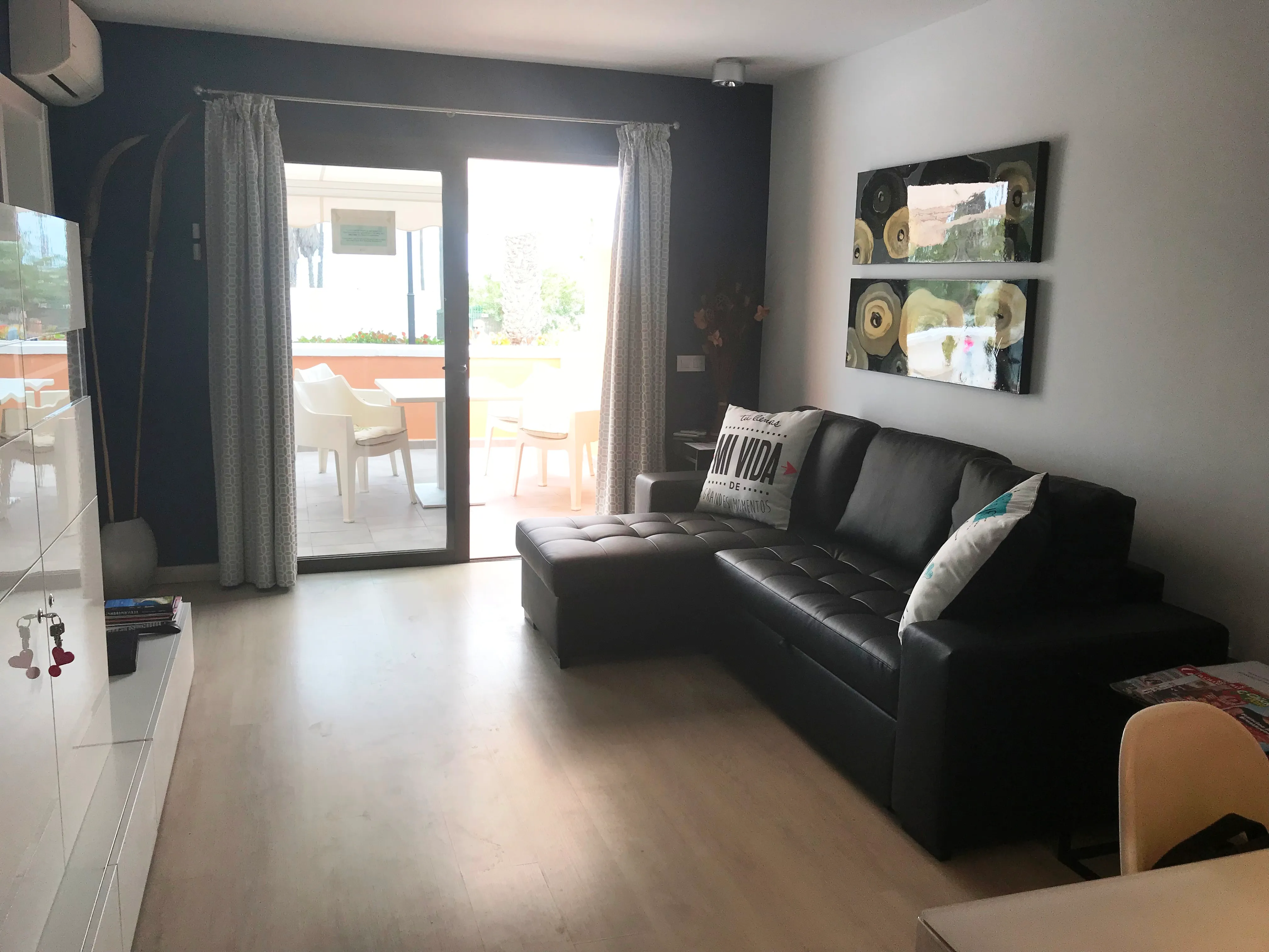 Heller Wohnraum mit Sofas, Essplatz und Zugang zur Terrasse
